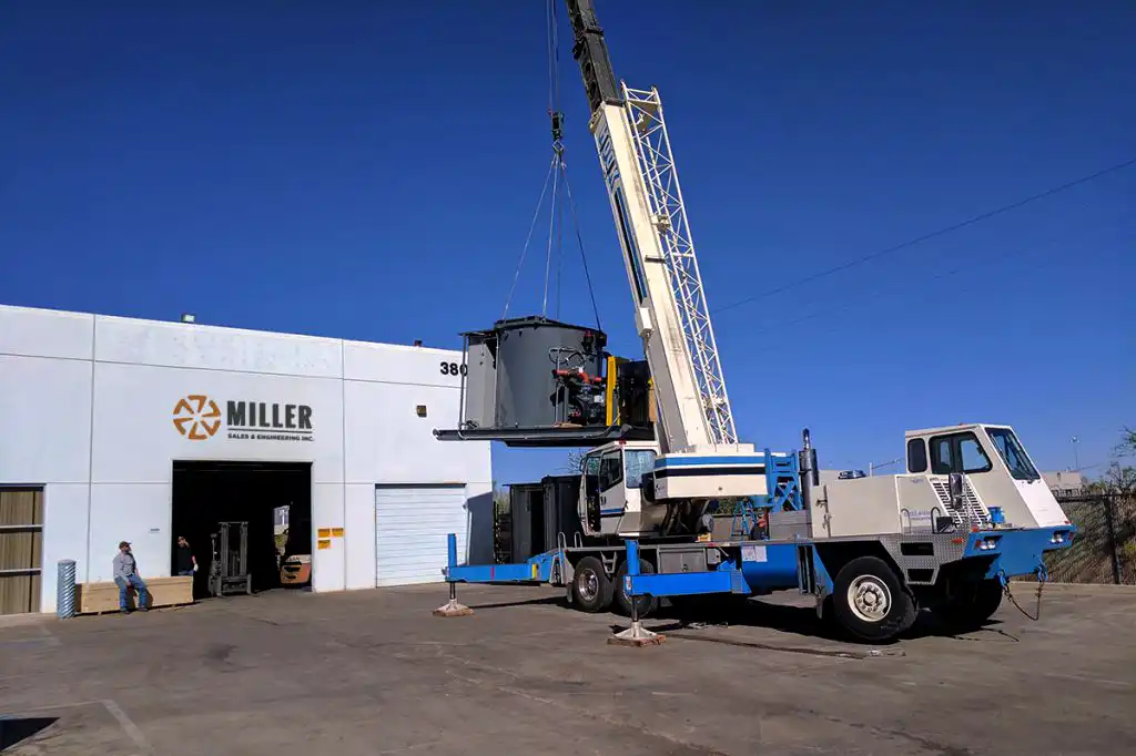 Une grue déplaçant des équipements au siège social de Miller Sales & Engineering